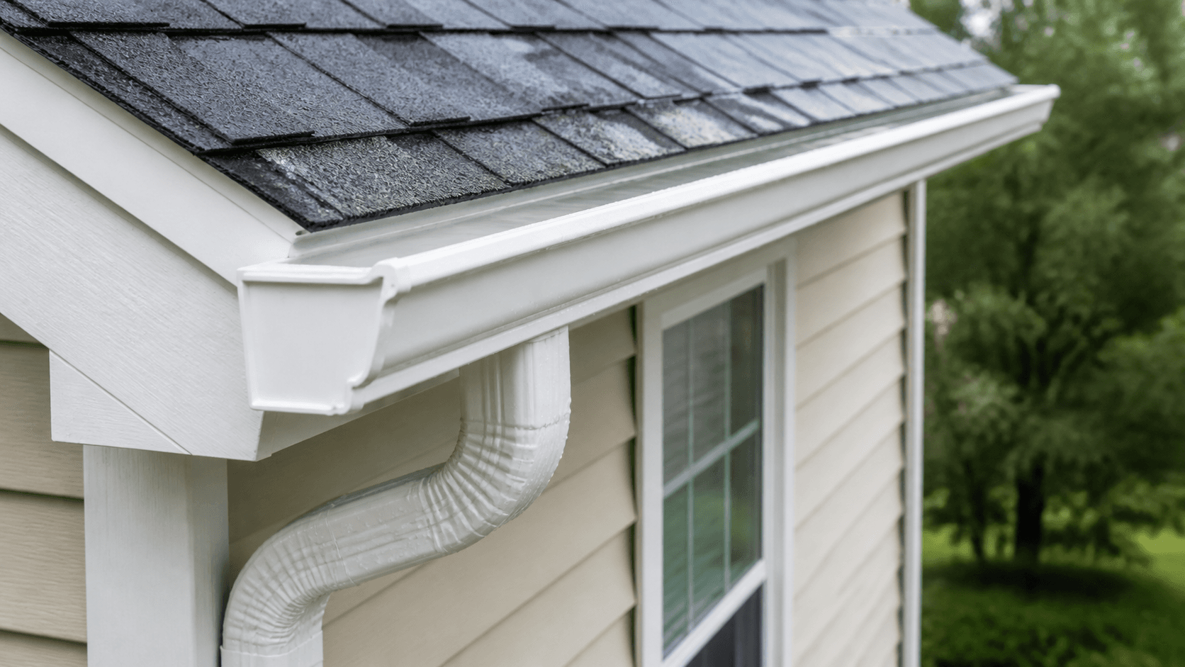 Clean gutter and downspout directing rainwater away from the home